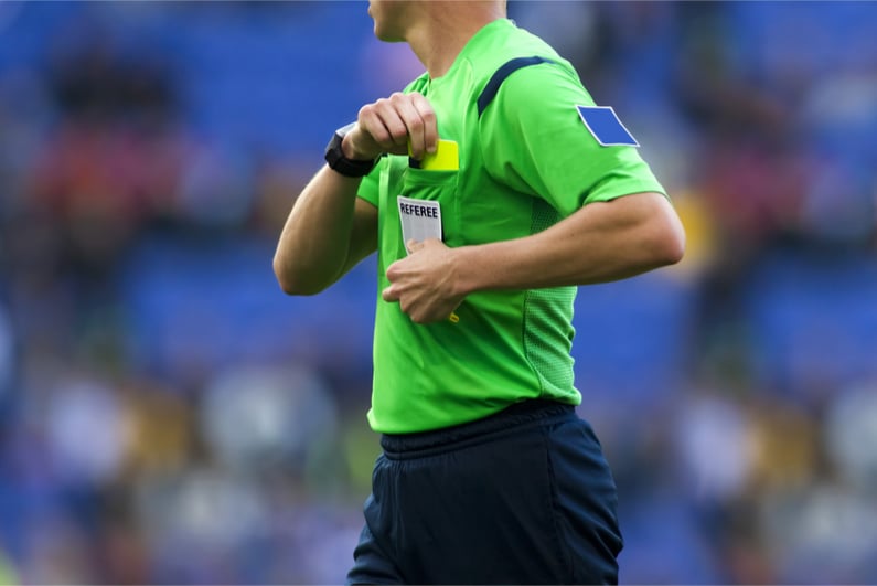 Soccer referee about to show a yellow card to a player during a match