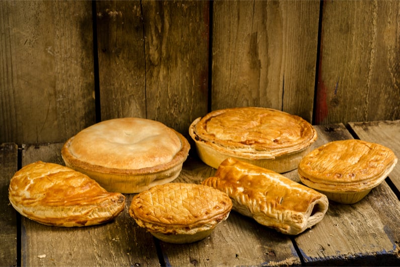 Selection of Pies, Pasties and sausage rolls on a wooden background