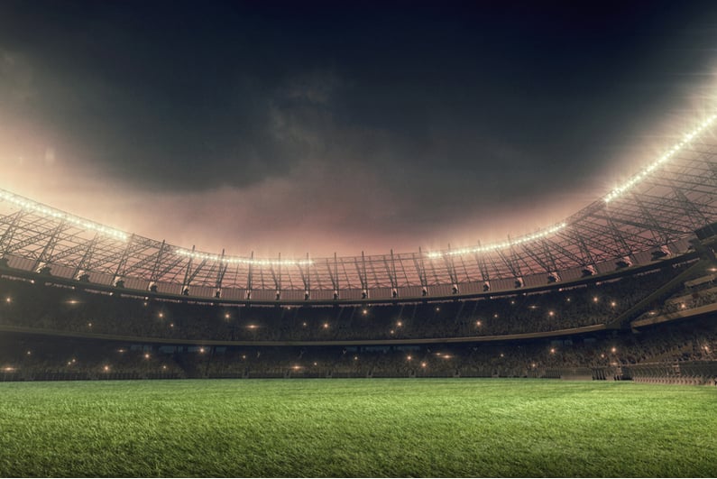 Illuminated soccer stadium under night sky