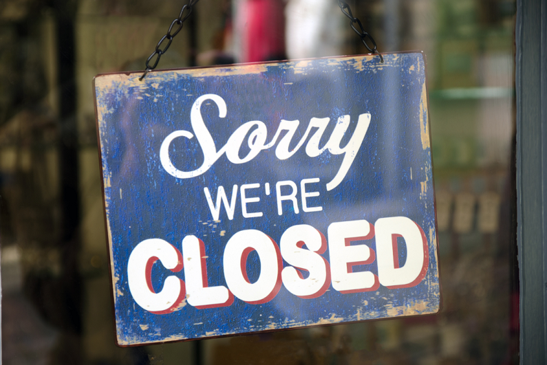 Vintage "Sorry, We're Closed" sign in a store window.