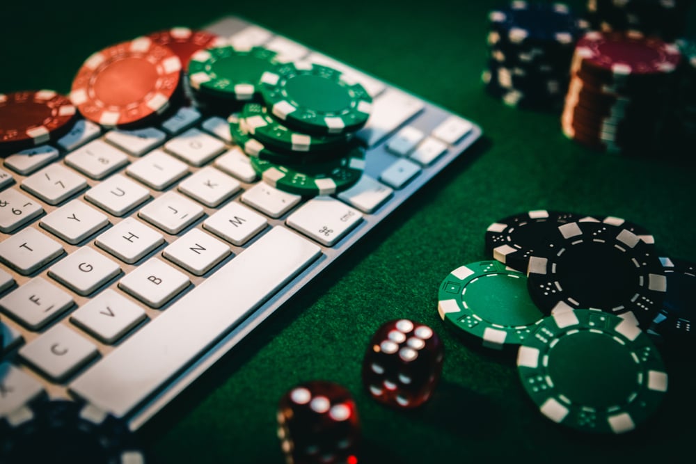 poker chips and dice on and around computer keyboard