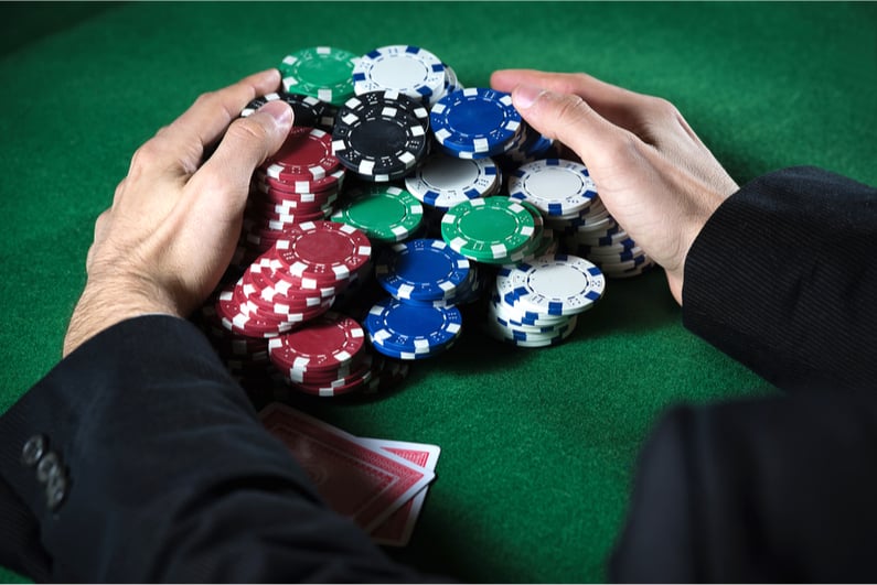 Man scooping large poker pot