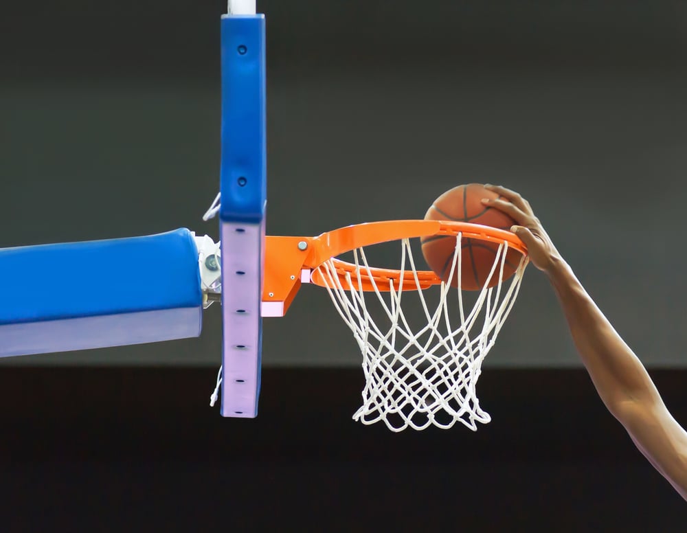 basketball player's arm throwing the ball into the hoop