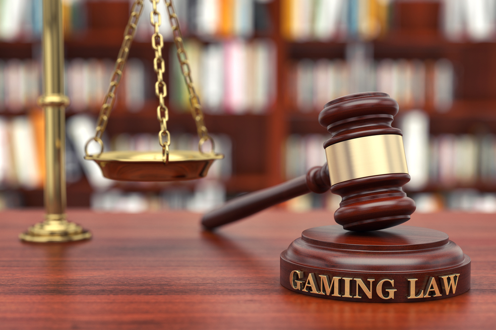 A judges gavel labeled with 'Gaming Law' next to scales