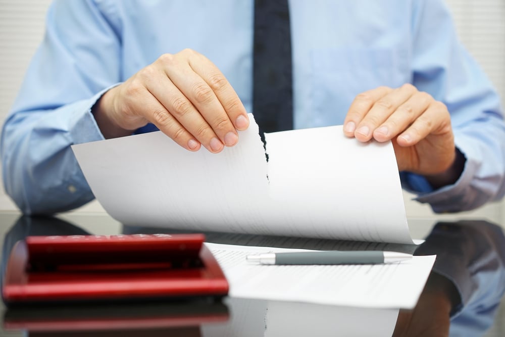 Man ripping up document