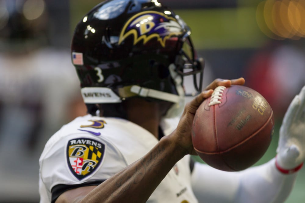 Baltimore Ravens player holding a football in one hand