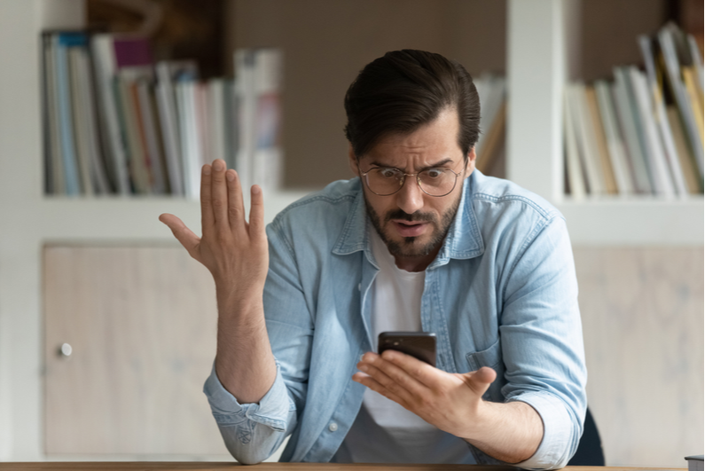 Man frustrated with something on his smartphone